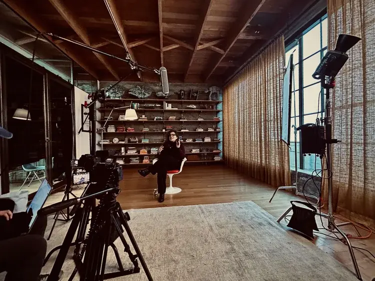 Wide production setup with camera, lighting, and talent inside an industrial studio